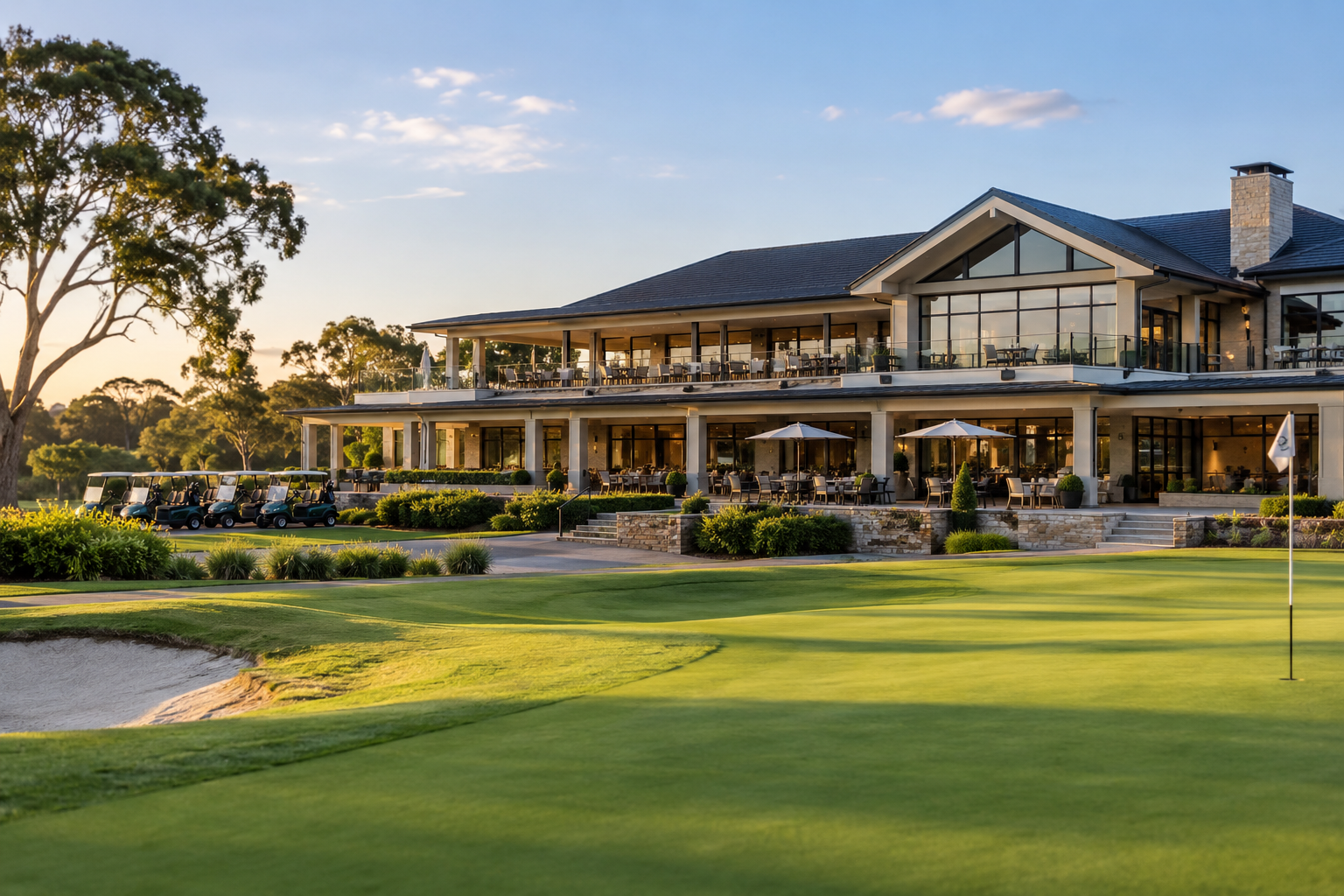 Golf clubhouse, cart fleet and putting green at sunset